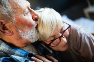 Happy romantic senior couple hugging and enjoying retirement at home