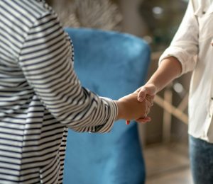 Woman shaking hand of tax professional after helpful conversation